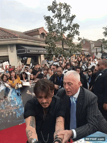 GIF animado (96484) Johnny depp intentando firmar los posters de todas sus fans